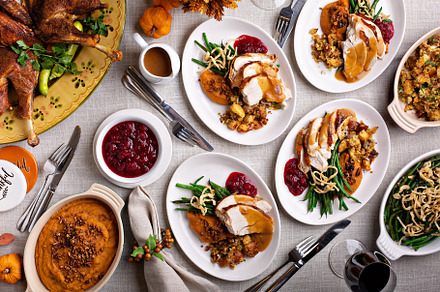 Festive Thankgiving dinner table with plates of food, a Food & Drink Photo by farwasser