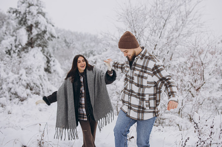 A young happy and loving couple walking in a snowy forest in the, a Person Photo by Cherkas Photography