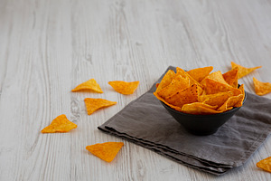 Crunchy Nacho BBQ Tortilla Chips in a Bowl, side view. Copy spac, a Food & Drink Photo by LiudmylaChuhunova