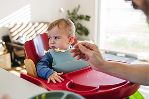 Caring father feeding toddler during, a Person Photo by HalfPoint