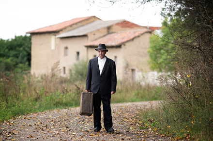 emigrant with suitcase and vintage suit leaving his village to l