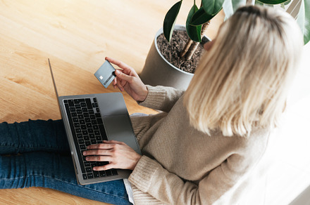 Young woman holding credit card and using laptop computer., a Person Photo by Olena Rudo