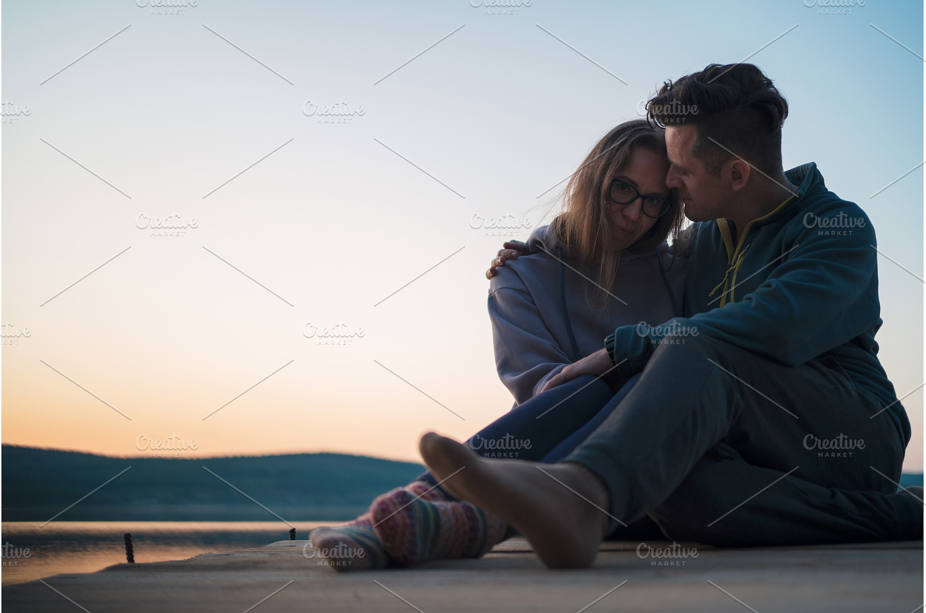 Woman lying down on the pier at lake, a Person Photo by Jan Jack Russo Media