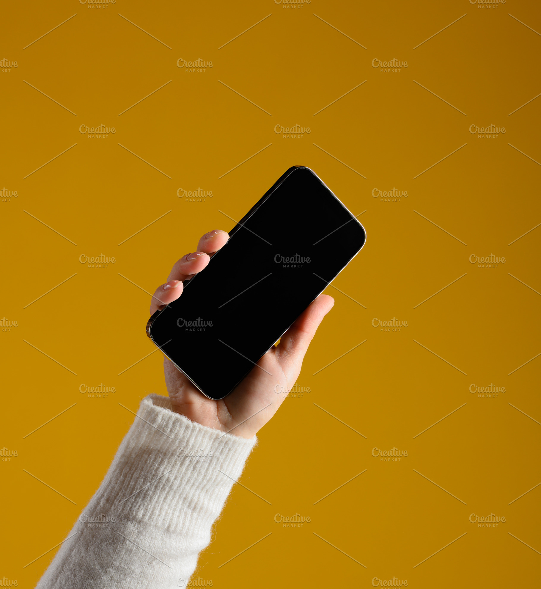 A man's hand in a white sweater holds a modern smartphone with a, a Technology Photo by ndanko