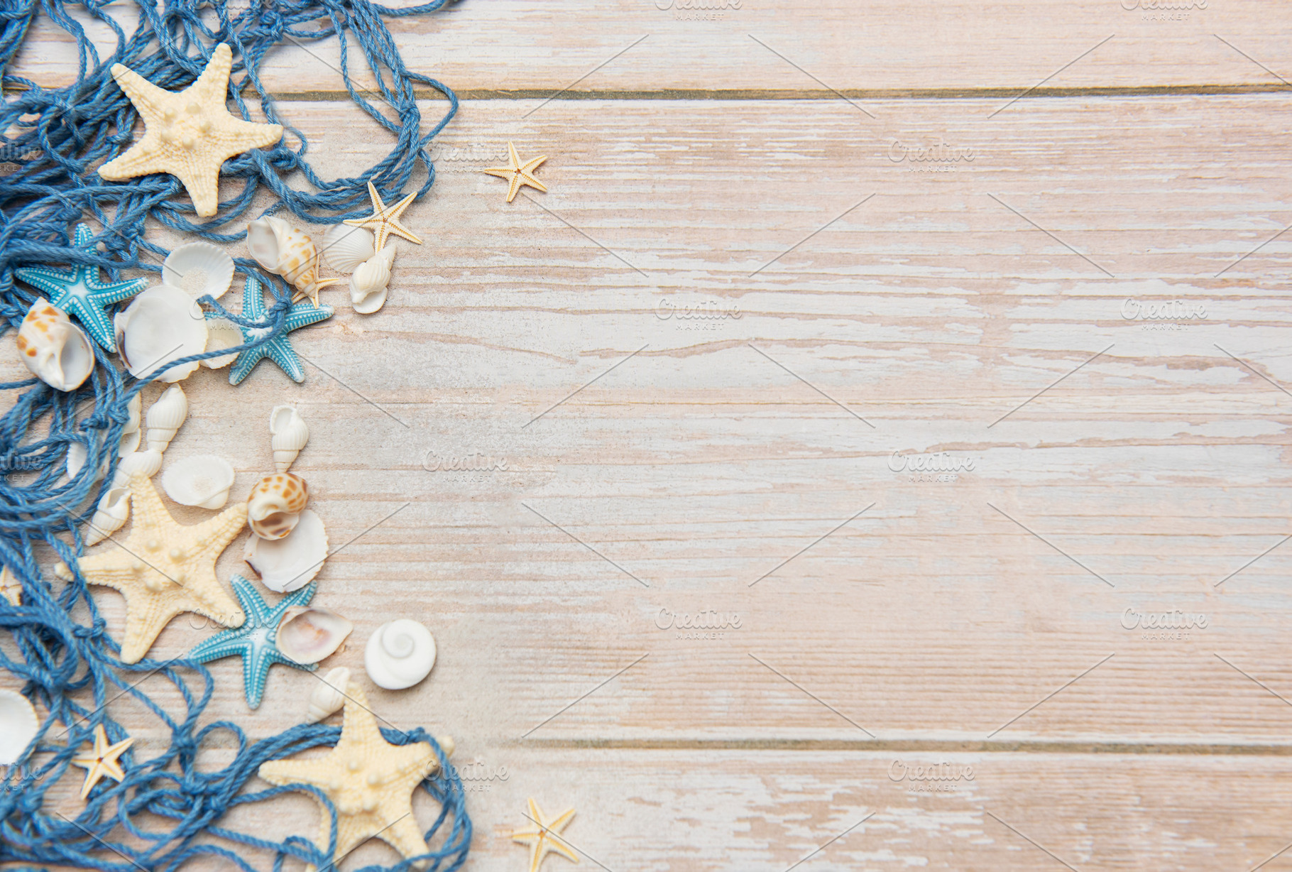 Fishing net, starfishes and seashells lying on wooden planks bac, a Holiday Photo by Olena Rudo