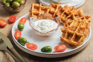 Top view of Homemade Potato Waffles, ricotta cheese and mayonese sauce. Served, a Food & Drink Photo by Budarinphoto