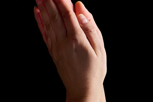 Two palms folded together in a prayer gesture on a black backgro, a Person Photo by ndanko