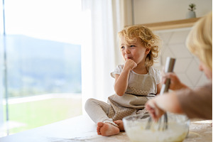 Little cute girl sitting on kitchen, a Food & Drink Photo by HalfPoint