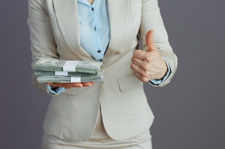Business owner woman in light business suit showing thumbs up, a Business Photo by Alliance Images