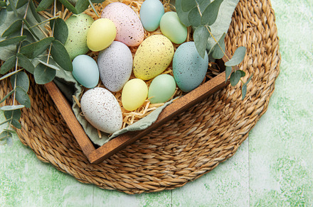 Easter decor. Colored Easter eggs in a wooden box on the table., a Holiday Photo by Olena Rudo