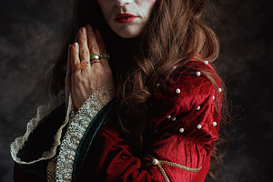 pensive medieval queen in red dress with crown praying, a Person Photo by Alliance Images