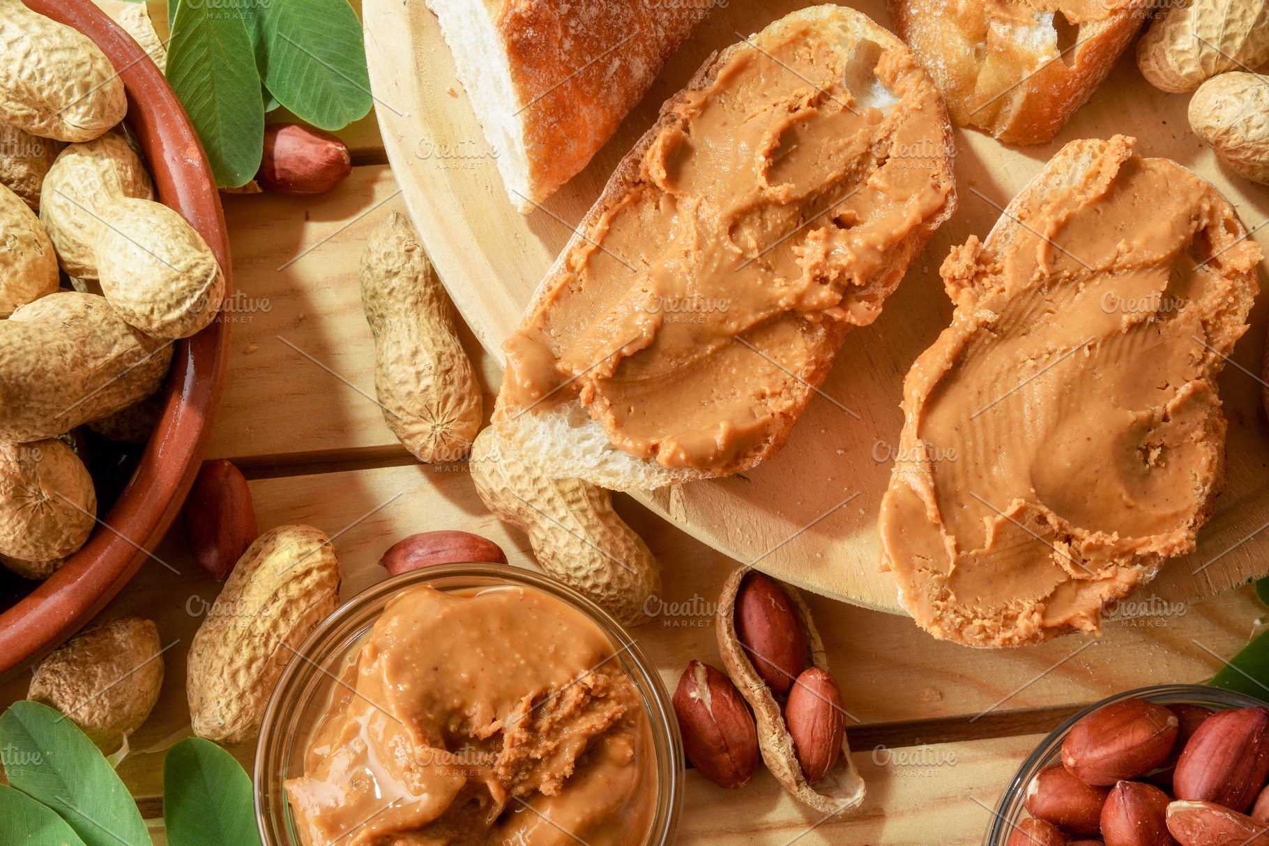 Homemade peanut butter and slices of bread on wooden outside, a Food & Drink Photo by Davizro's Market