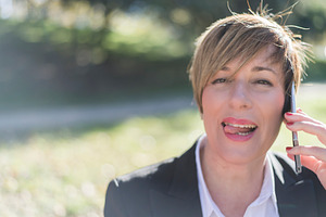 Smiling businesswoman talking on phone outdoors, a Photo by RF Images
