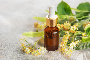 Linden essential oil in dropper bottle with fresh flowers, a Health & Medical Photo by Olena Rudo
