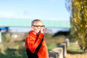 Senior man drinking water after outdoor exercise in nature, a Sports & Recreation Photo by RF Images