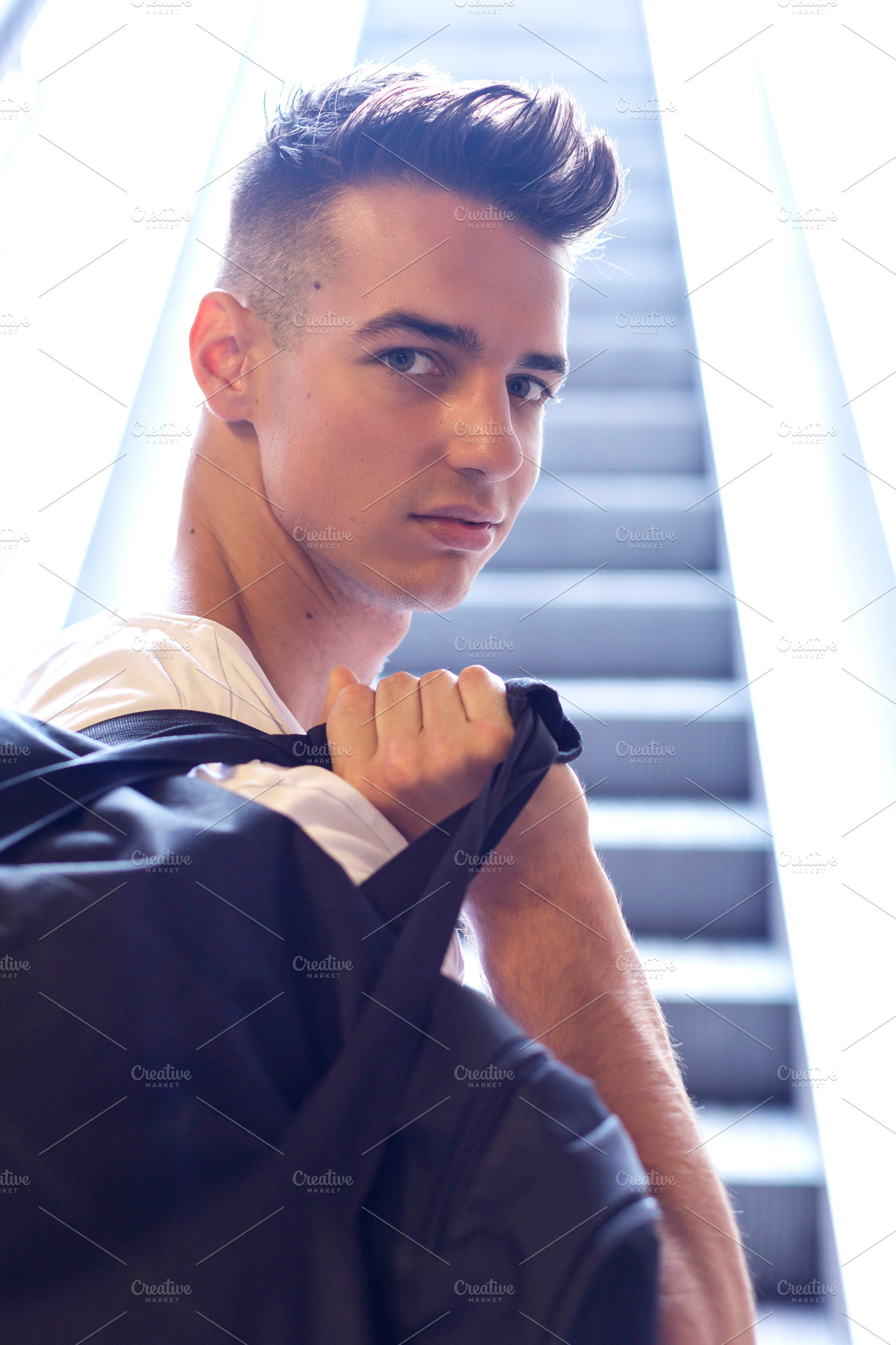 Young man posing with hands in hair by window, a Person Photo by RF Images