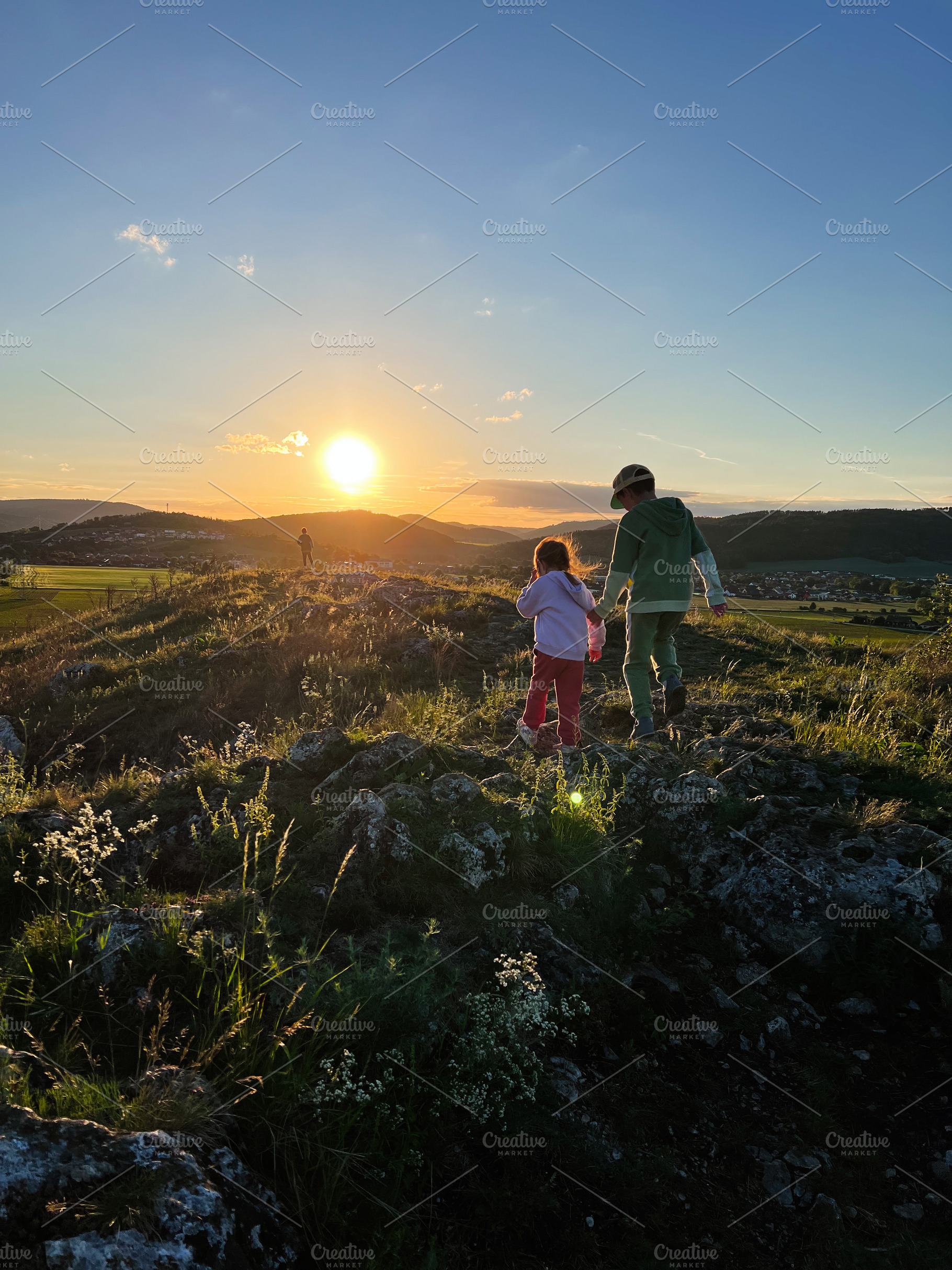 Children exploring nature during a beautiful sunset hike in the hills, a Photo by AS photostudio