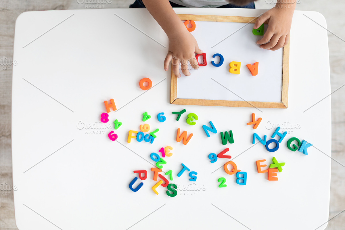 Top view of little kid hands making ABCD text on board with colorful letters du, a Photo by Prostock-Studio (Photo 1 of 2)