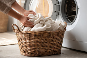 Woman putting clean towels in a wick, a Photo by Pixeness Studio