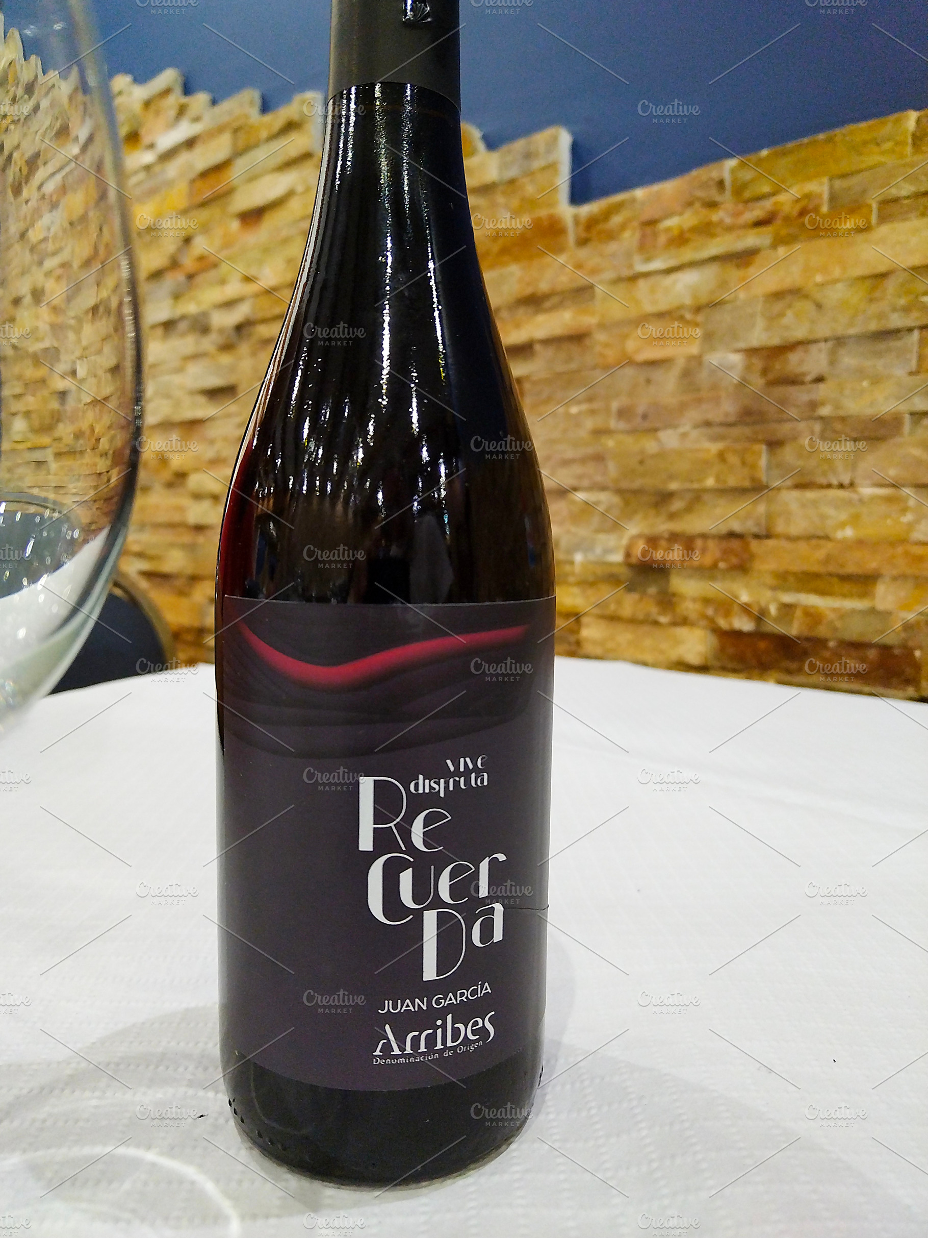 Bottle of red wine on white tablecloth with glass, a Food & Drink Photo by DanFLCreativo