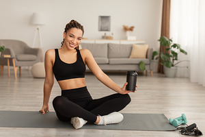 Black Fitness Lady Holding Cup Drinking Water During Workout Indoor, a Photo by Prostock-Studio