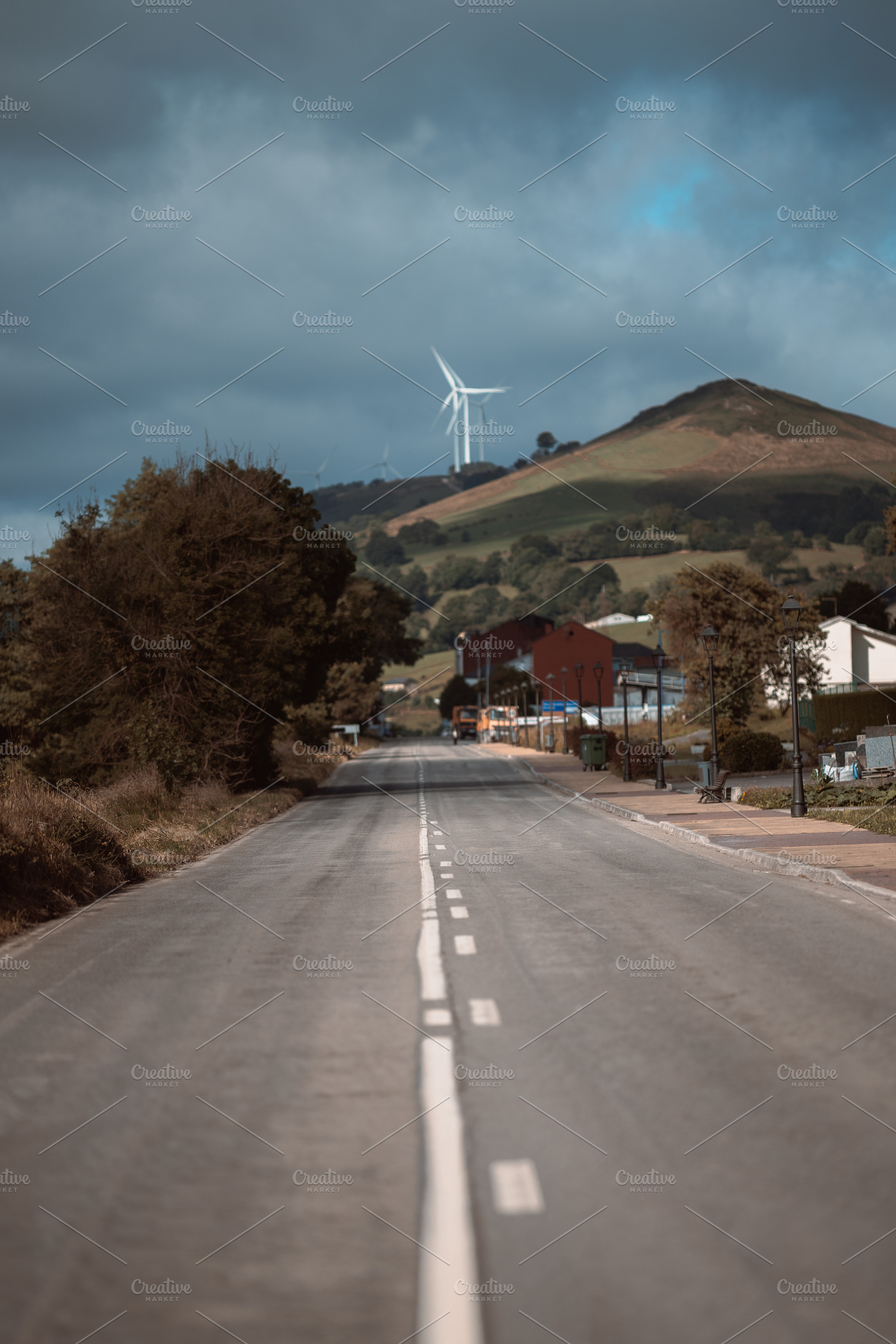 Road to hill with wind turbines, an Industrial Photo by SkyNext