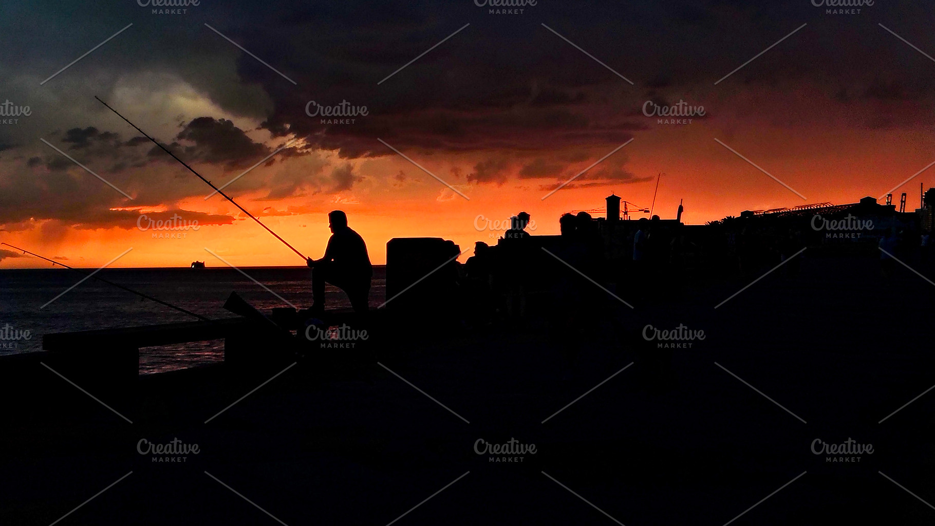 Silhouettes of fishermen casting lines under dramatic sunset sky, a Nature Photo by DanFLCreativo
