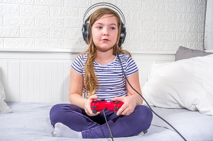 Llittle child kid girl playing video games, a Photo by Rimma