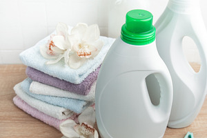 Laundry products with clean towels and orchids on wood, an Industrial Photo by Olena Rudo