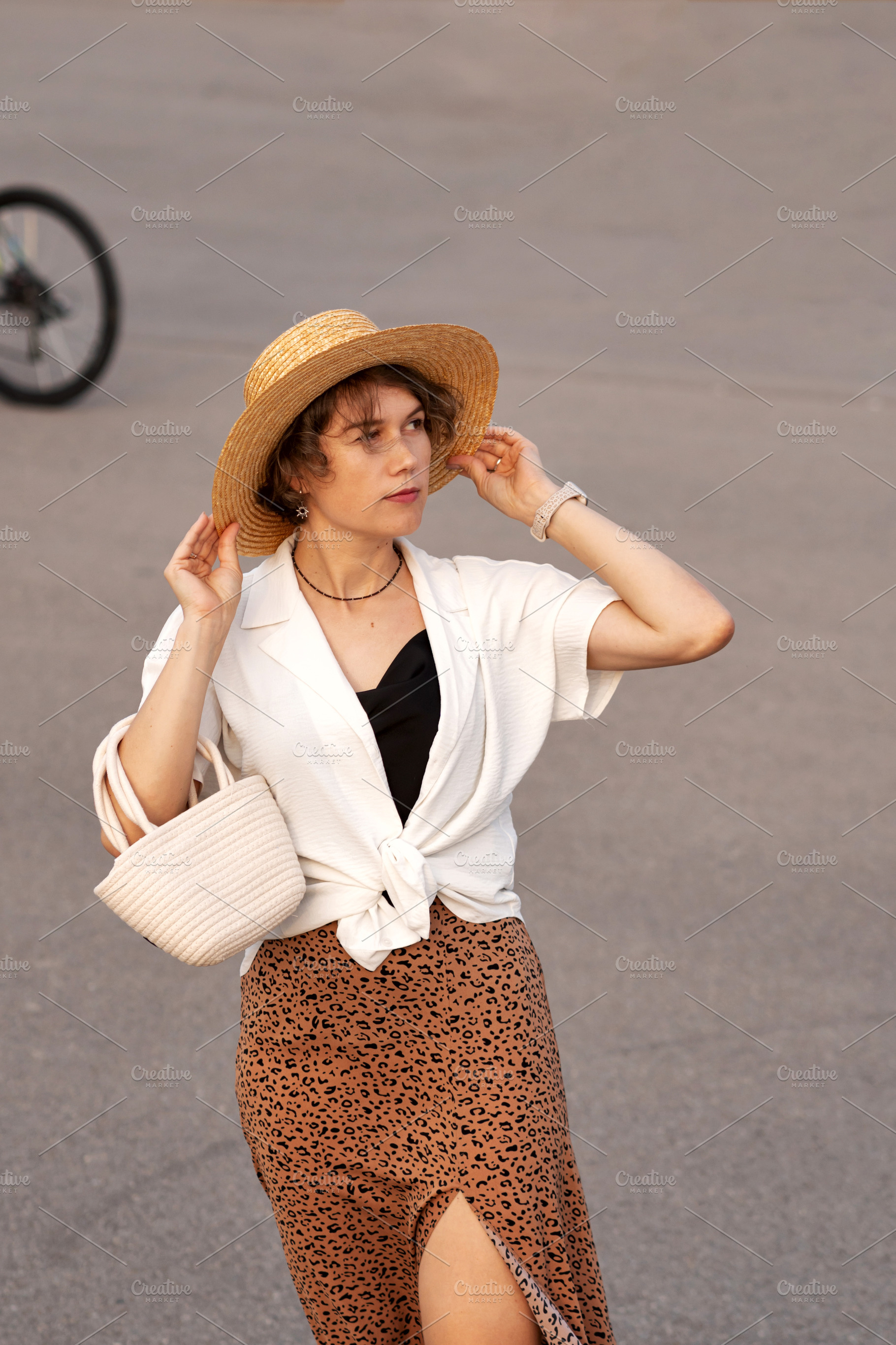Woman adjusts straw hat posing, a Person Photo by Elena Vagengeim