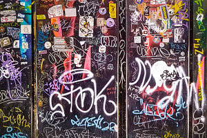 Graffiti-covered metal doors with urban stickers, an Abstract Photo by DanFLCreativo