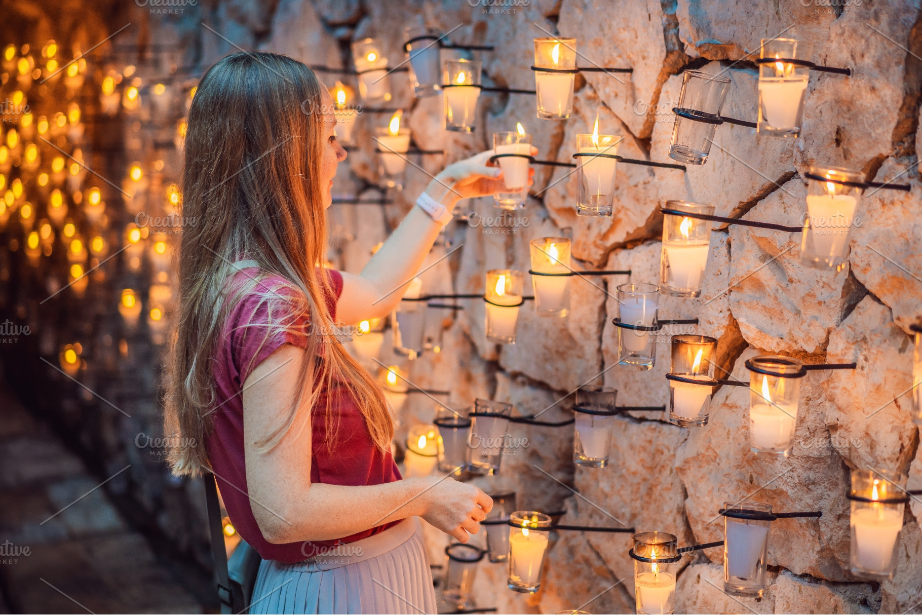 Woman exploring a warmly lit wall of, a Person Photo by Elizaveta Galitskaya