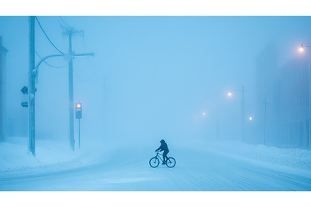 Cyclist in snowy urban street amid, a Transportation Photo by Lermont51