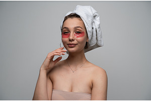 Young woman applying red eye patches, a Health & Medical Photo by volodymyrshtun13795