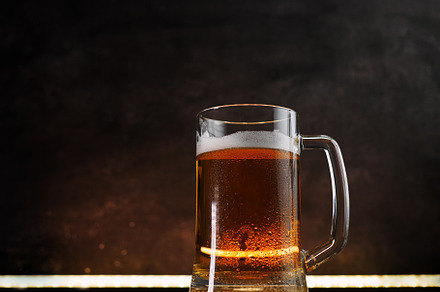 Light beer mug on a dark background. Back light, copy space