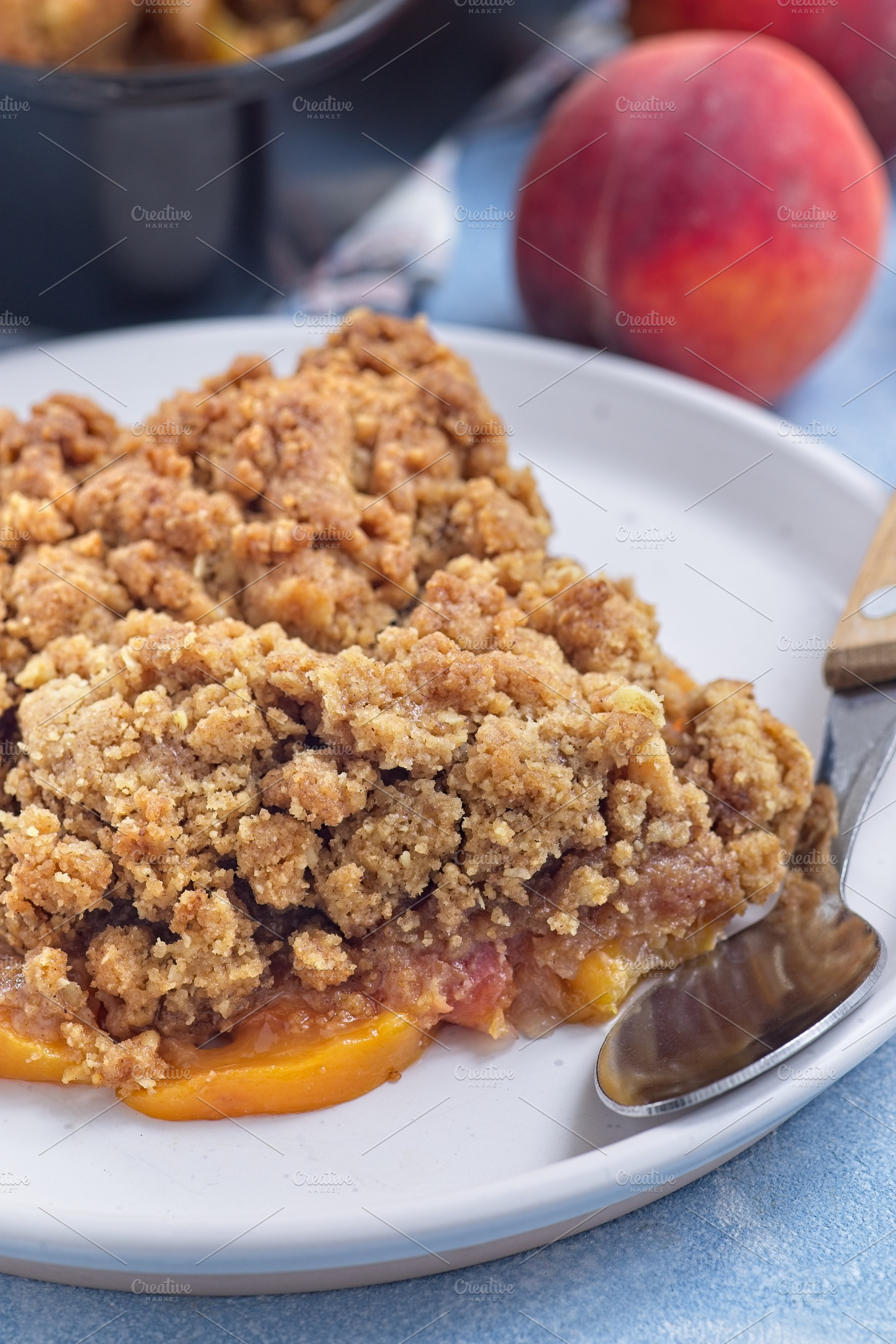 Peach Crisp or cobbler with brown sugar and oat streusel on plate, vertical, cl, a Food & Drink Photo by iuliia_n