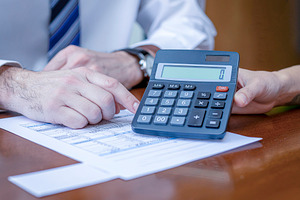 Financial review with calculator and documents, a Photo by DanFLCreativo