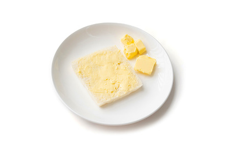 Butter on a slice of bread isolated on white background on a pla, a Food & Drink Photo by Tampatra