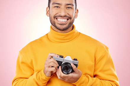 Portrait, photographer with a camera and smile for photography, taking a picture for art, travel or record of a happy memory. Creative, man with happiness and shooting on retro or vintage film, a Photo by Peopleimages.com