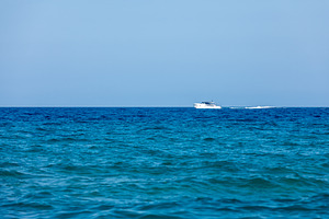 White yacht cruising on a calm blue ocean under clear sky, symbolizing travel,, a Transportation Photo by Ales Munt