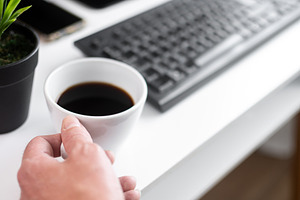 Hand Holding Cup of Black Coffee at Modern Home Office Desk, a Person Photo by etorres69