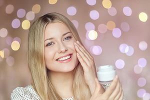 Young woman applying face cream to glowing skin, enjoying beauty, a Person Photo by Studio ANNA