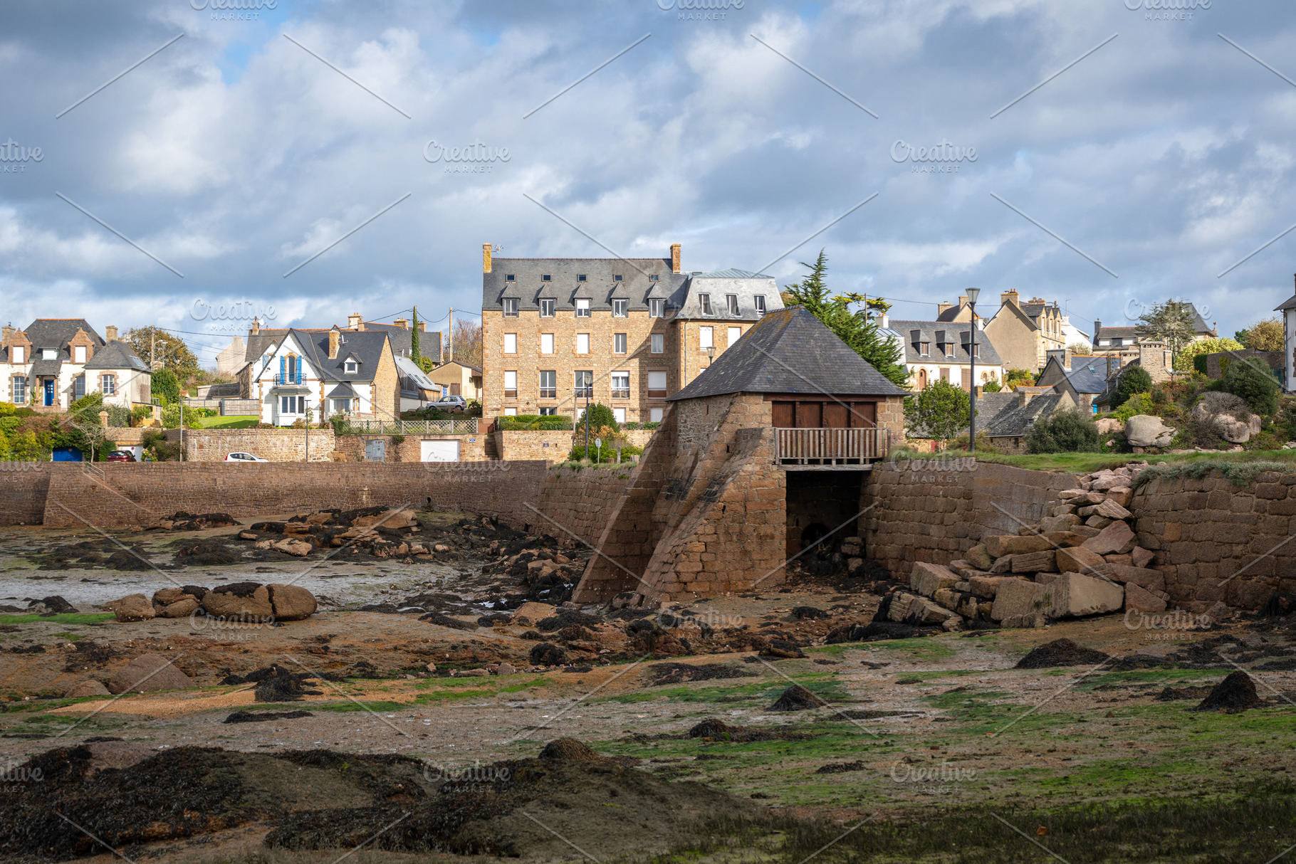 Historic tidal mill surrounded by granite houses in Tregastel, B, an Architecture Photo by GoodGoods