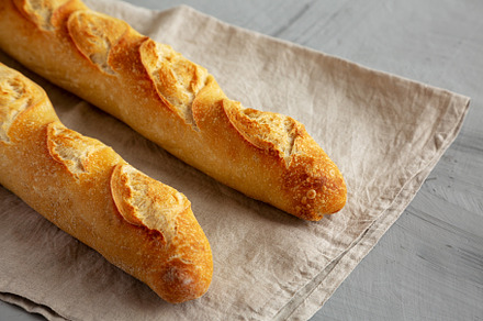 Homemade French Bread Baguette on a gray background, side view., a Food & Drink Photo by LiudmylaChuhunova