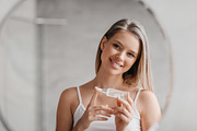 Daily skincare routine concept. Happy woman holding bottle of hyaluronic acid s, a Photo by Prostock-Studio (Thumbnail 2 of 2)