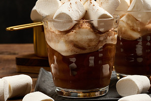 Two glasses of hot chocolate with fluffy marshmallows on a slate, a Food & Drink Photo by ndanko