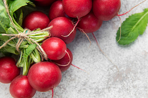 Fresh organic radishes with green leaves on light background, a Food & Drink Photo by Olena Rudo