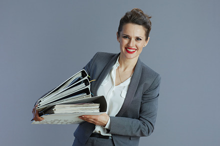 smiling trendy small business owner woman isolated on grey, a Business Photo by Alliance Images