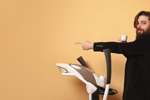 Confident young businessman holding coffee and pointing while st, a Person Photo by Ales Munt