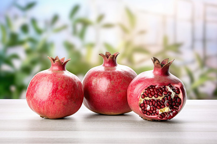 Fresh ripe pomegranate on white wooden background, a Food & Drink Photo by AlyaAnd